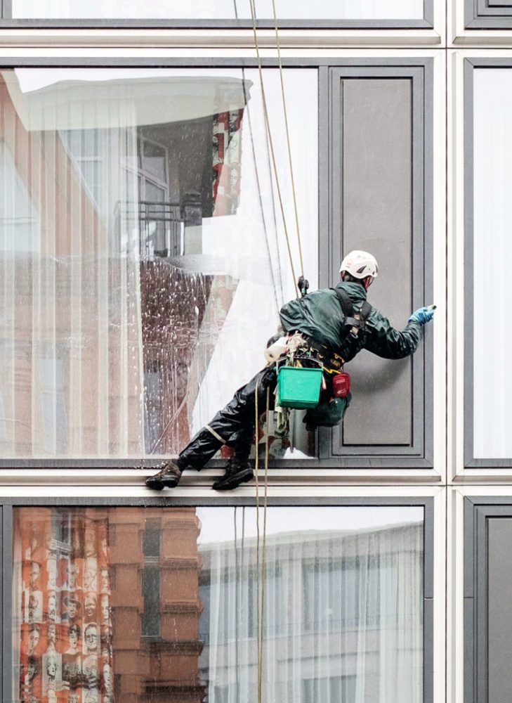 man cleaning exterior window